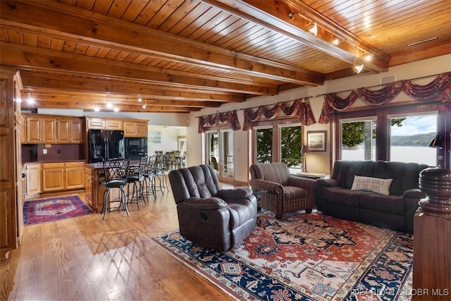 living room featuring light wood-type flooring, beam ceiling, and wooden ceiling