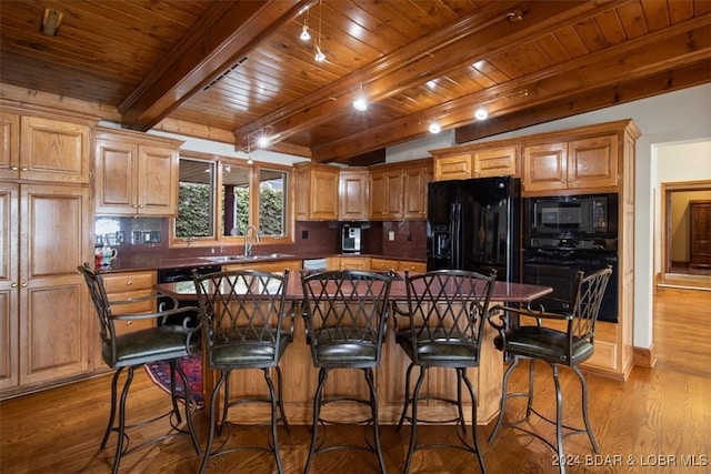 kitchen featuring wood ceiling, light hardwood / wood-style floors, beamed ceiling, sink, and black appliances