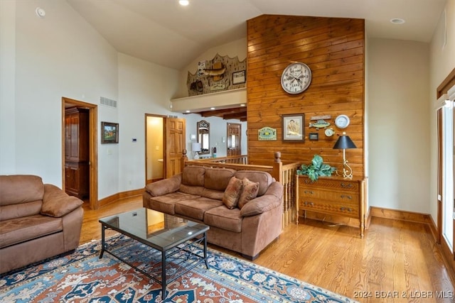 living room with light wood-type flooring and high vaulted ceiling