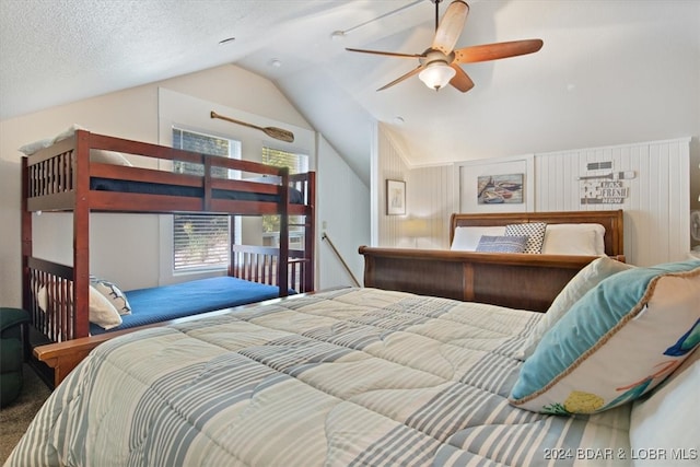 carpeted bedroom featuring vaulted ceiling, a textured ceiling, and ceiling fan