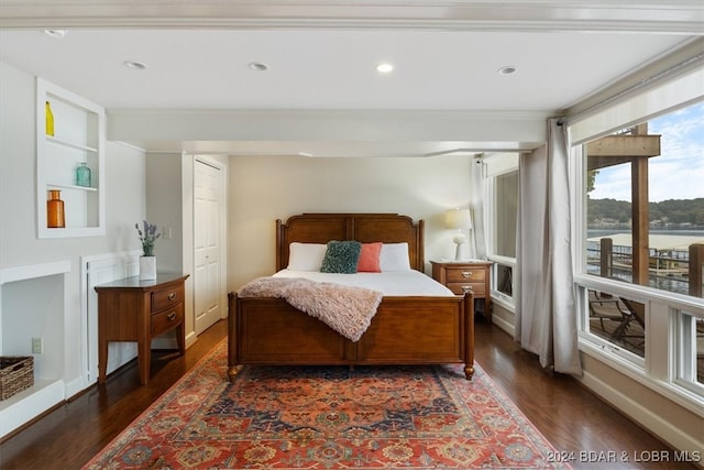 bedroom with ornamental molding and dark wood-type flooring