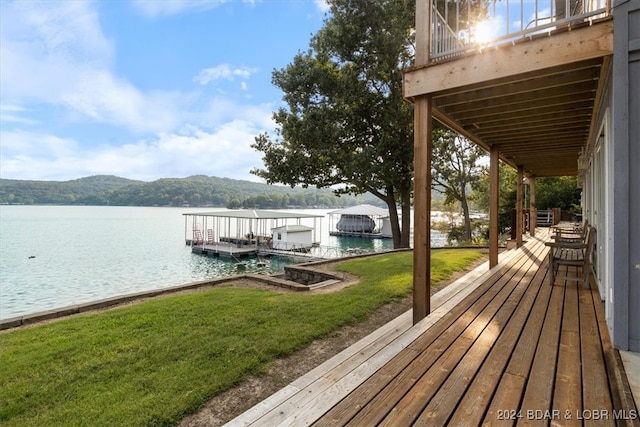 view of dock with a water and mountain view and a yard