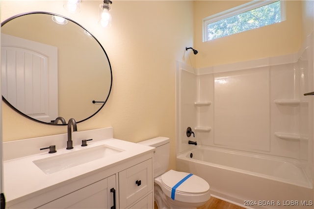 full bathroom with hardwood / wood-style flooring, shower / washtub combination, vanity, and toilet