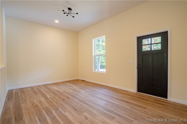 foyer entrance with a notable chandelier, light hardwood / wood-style flooring, and a healthy amount of sunlight