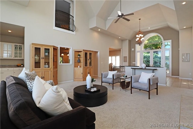 living room featuring a chandelier, high vaulted ceiling, and light carpet