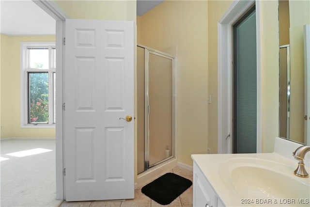 bathroom featuring vanity, tile patterned flooring, and a shower with door