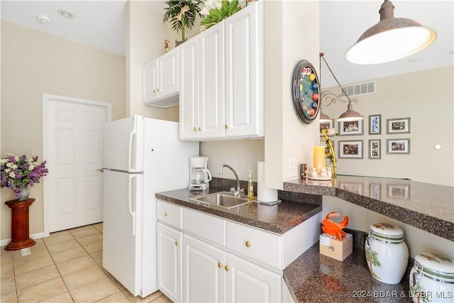 kitchen with sink, light tile patterned floors, white fridge, pendant lighting, and white cabinets