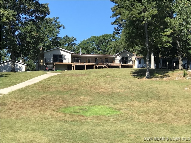 view of front facade with a front lawn, an outdoor structure, and a deck