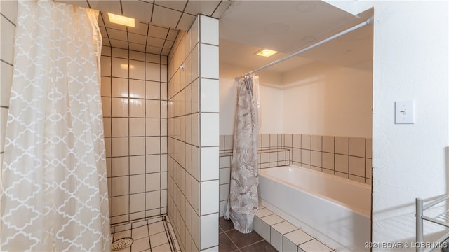 bathroom with shower / bath combination with curtain and tile patterned flooring