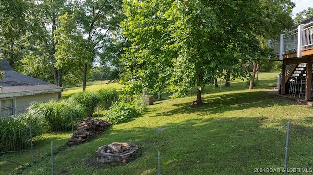 view of yard featuring a deck and an outdoor fire pit