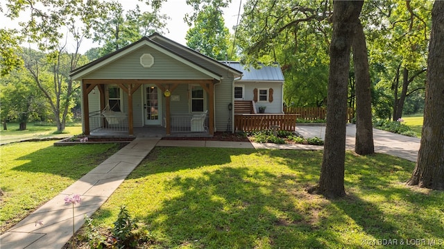 bungalow-style house with a front yard and covered porch