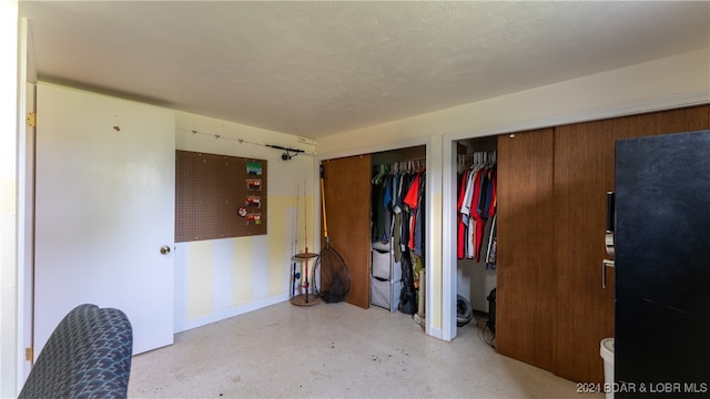 unfurnished bedroom featuring multiple closets and a textured ceiling