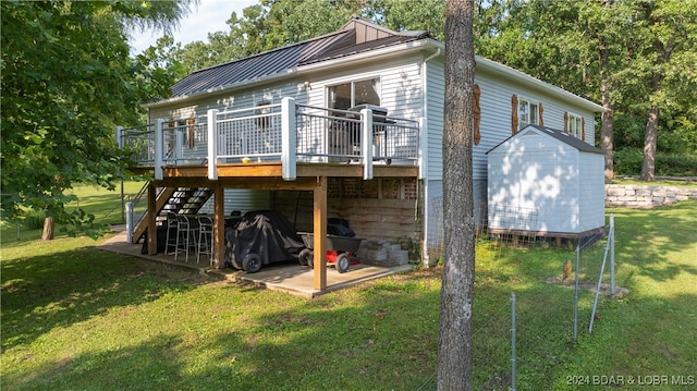 back of property with a storage unit, a wooden deck, and a yard