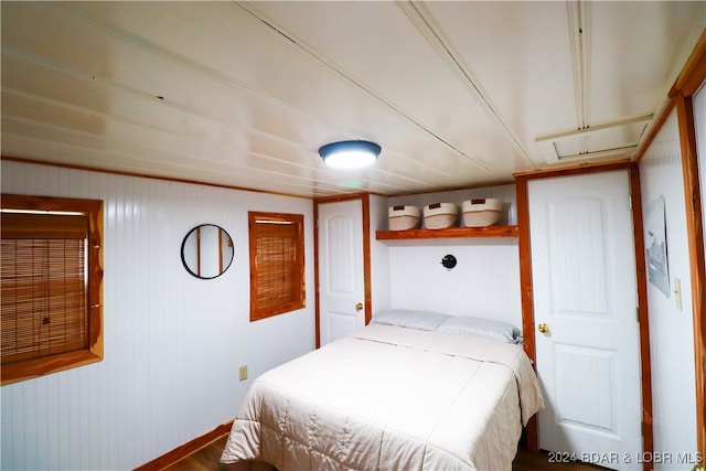 bedroom featuring wooden walls