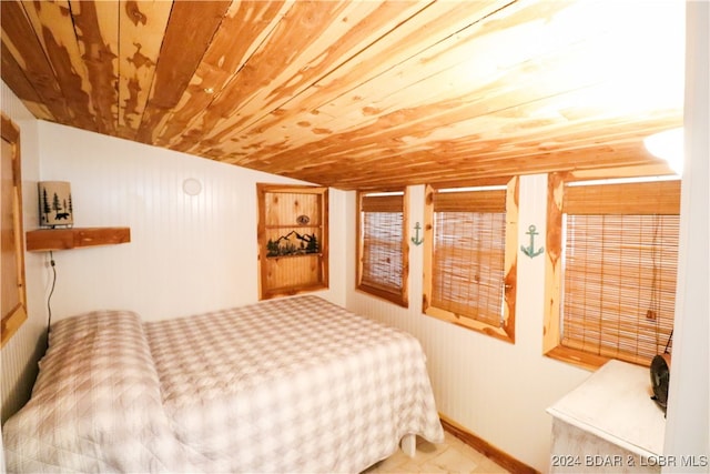 bedroom with wooden walls, wood ceiling, and vaulted ceiling