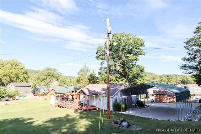 view of yard featuring a carport and a wooden deck