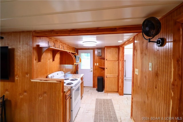 kitchen featuring wooden walls and white electric stove