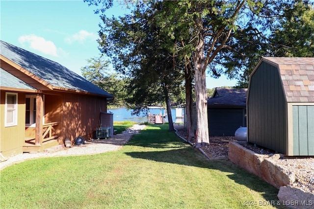 view of yard with a water view and a shed