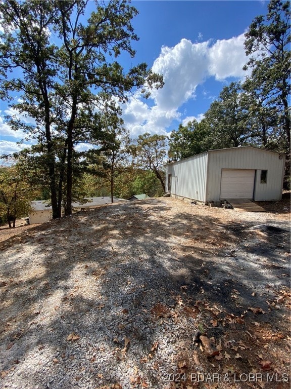 view of yard featuring a garage and an outdoor structure