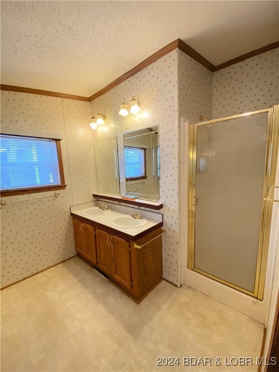 bathroom with ornamental molding, vanity, an enclosed shower, and a textured ceiling