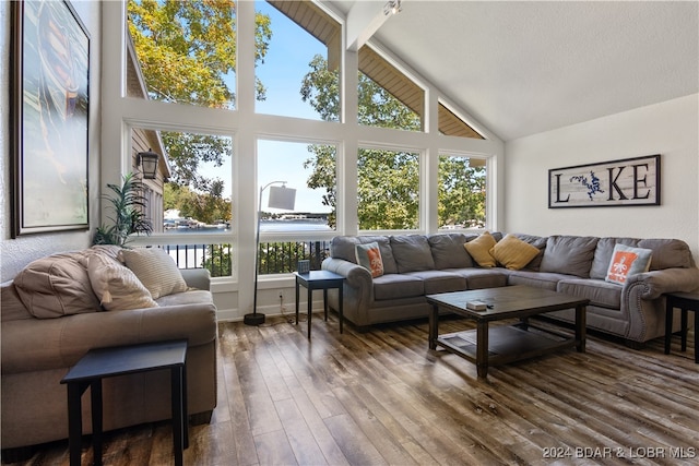 living room with high vaulted ceiling, a wealth of natural light, beamed ceiling, and hardwood / wood-style floors