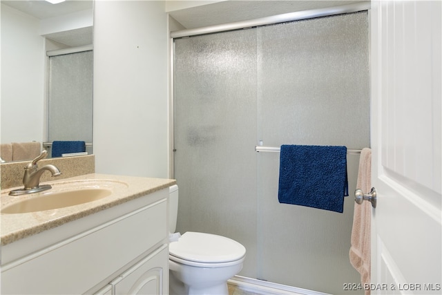 bathroom featuring walk in shower, vanity, and toilet