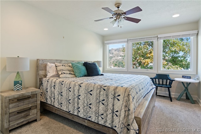 bedroom featuring a textured ceiling, ceiling fan, and light colored carpet