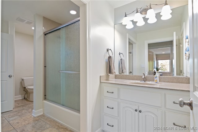 full bathroom with tile patterned floors, combined bath / shower with glass door, vanity, and toilet