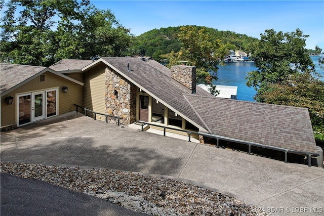 view of front of house featuring a water view and french doors