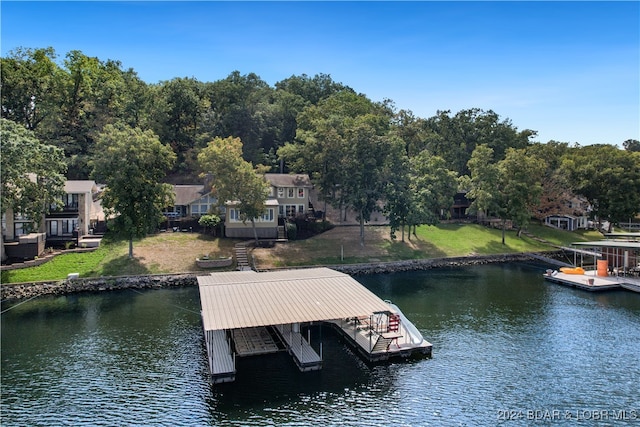 dock area with a water view and a yard