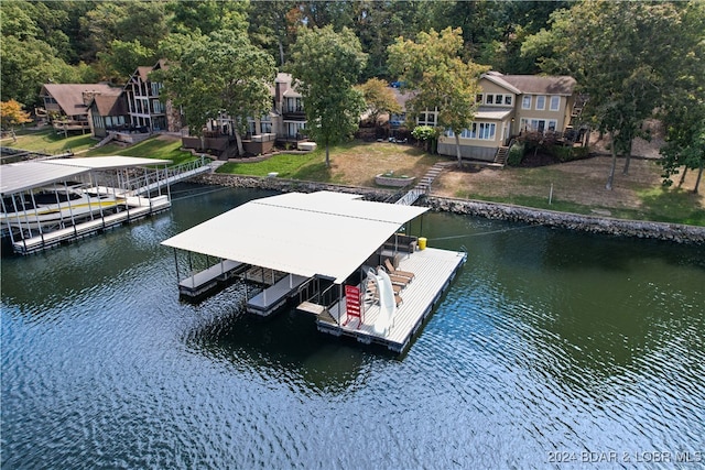 view of dock with a lawn and a water view