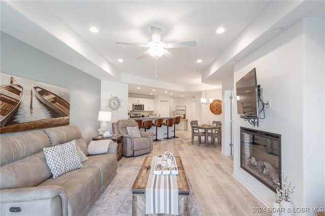 living room featuring ceiling fan and light hardwood / wood-style flooring