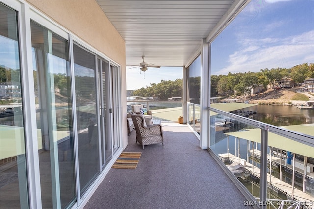 balcony featuring ceiling fan and a water view