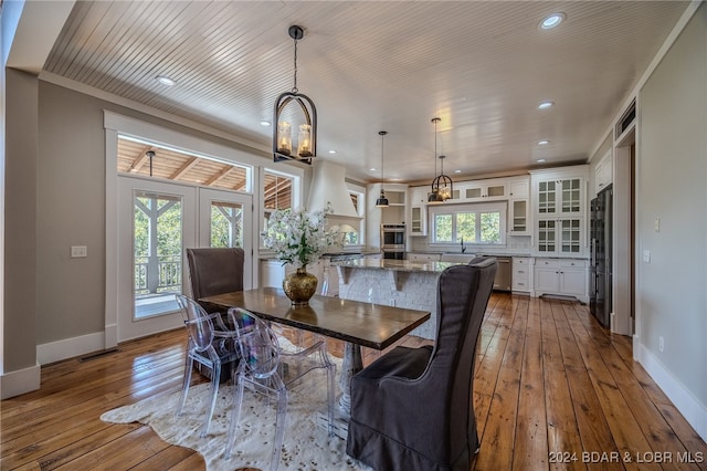 dining room featuring french doors, ornamental molding, a notable chandelier, and light hardwood / wood-style floors