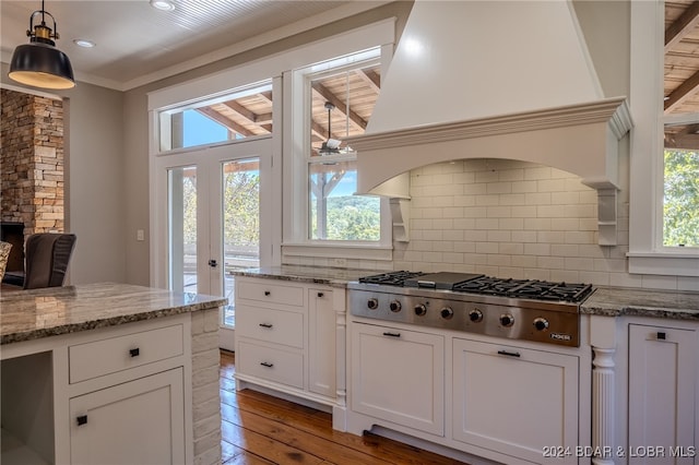 kitchen featuring stainless steel gas stovetop, a wealth of natural light, white cabinets, and hardwood / wood-style floors