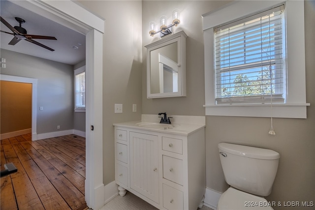 bathroom with hardwood / wood-style flooring, vanity, toilet, and a wealth of natural light