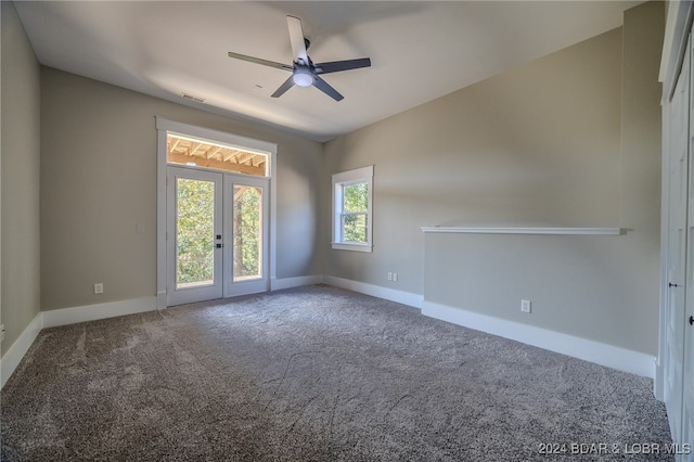 carpeted spare room featuring ceiling fan and french doors