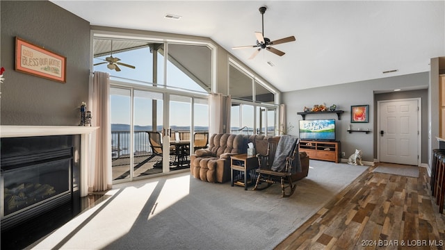 living room with hardwood / wood-style floors, ceiling fan, and high vaulted ceiling