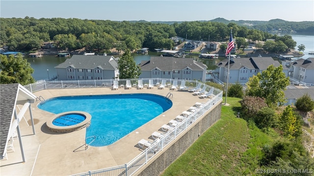 view of swimming pool with a patio and a water view