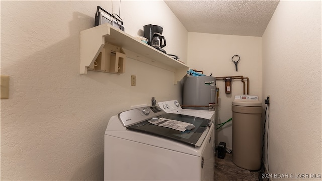 washroom featuring a textured ceiling, washer and dryer, and water heater