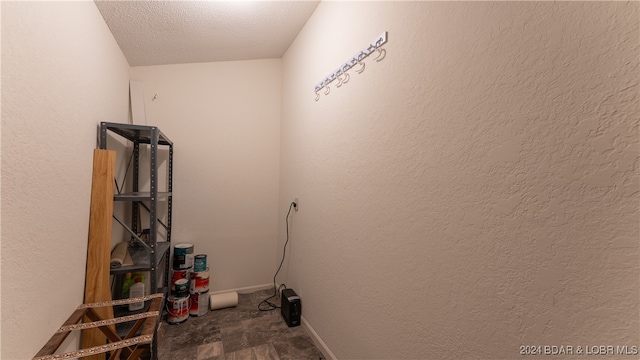 clothes washing area featuring a textured ceiling