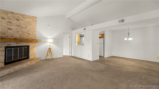 unfurnished living room featuring vaulted ceiling with beams, carpet, and a large fireplace