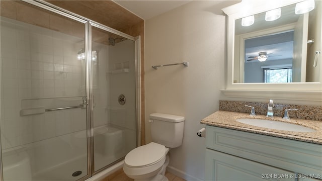 bathroom featuring vanity, toilet, and a shower with shower door