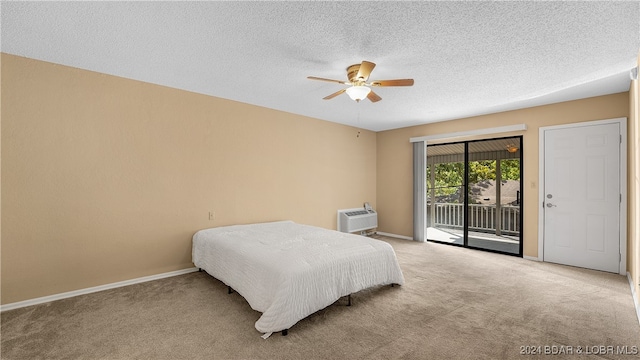 bedroom with access to outside, ceiling fan, a textured ceiling, light carpet, and a wall mounted air conditioner