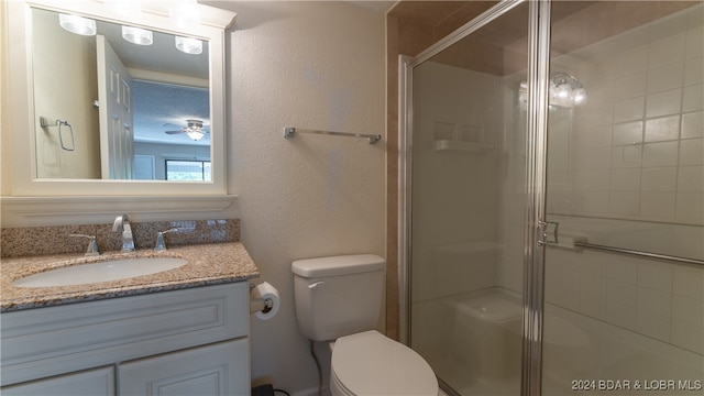 bathroom with vanity, a shower with shower door, and toilet