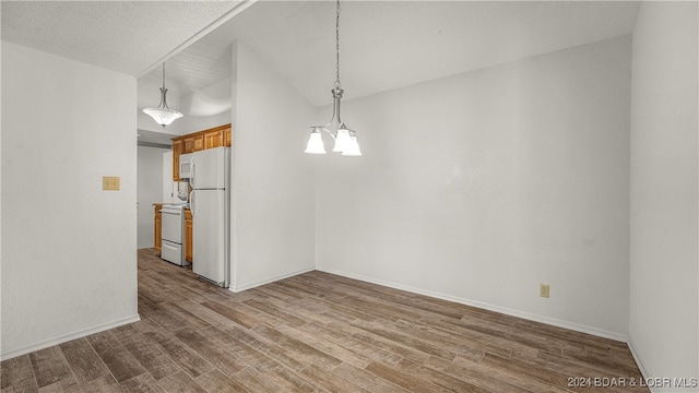 unfurnished room featuring wood-type flooring, a textured ceiling, and a chandelier