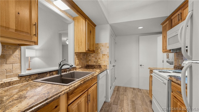 kitchen featuring light hardwood / wood-style flooring, sink, white appliances, and decorative backsplash