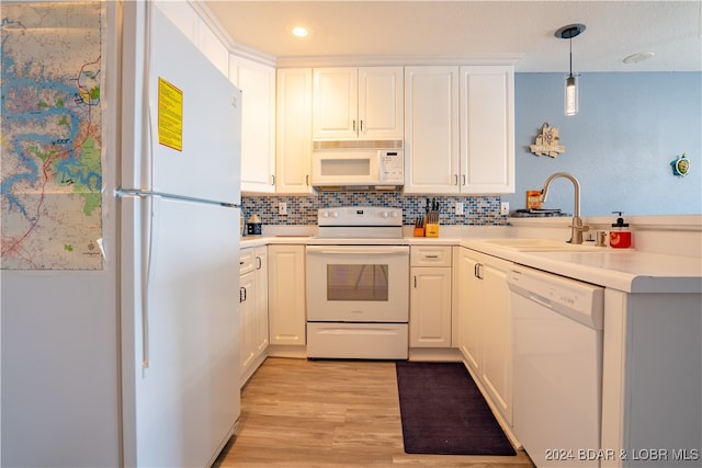 kitchen featuring sink, pendant lighting, light wood-type flooring, white cabinetry, and white appliances