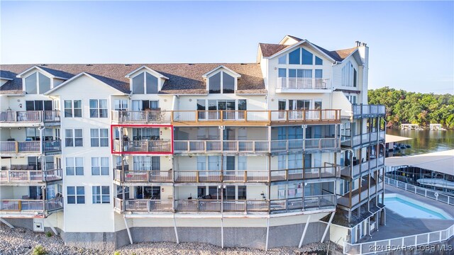 view of building exterior with a water view and a swimming pool