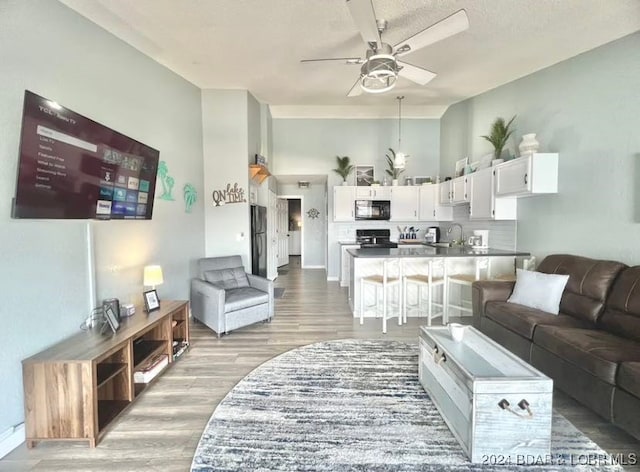 living room with ceiling fan and light hardwood / wood-style floors